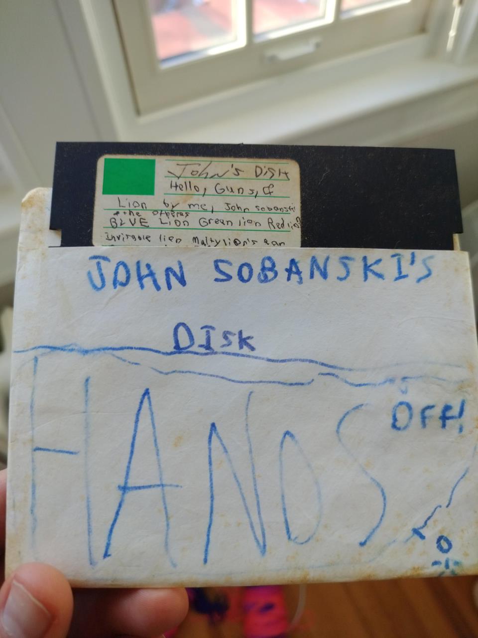 A picture of an old floppy disk that reads "John Sobanski's Disk - Hands Off!